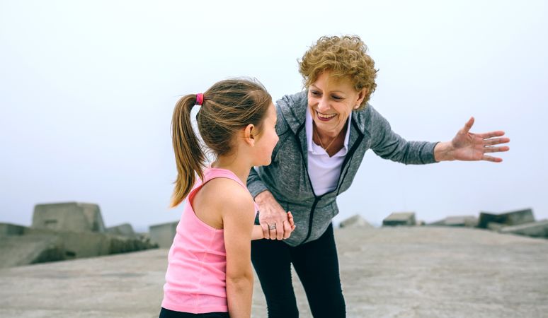 Mature sportswoman talking to little girl