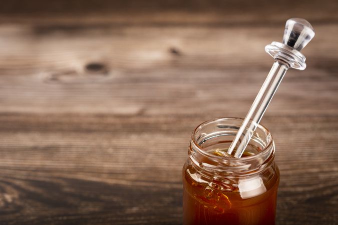 Honey in glass jar on the table.