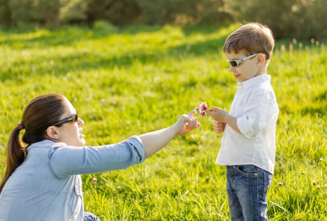 Son giving a bouquet of flowers to his mother in a field