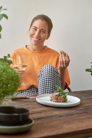 Smiling female having lunch and looking at camera in kitchen