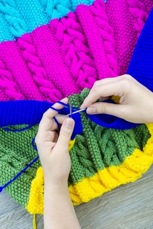 Woman knitting colorful sweater