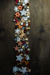 Top view of flat cut out Christmas ornaments in center of wooden table