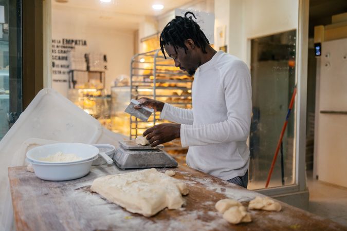 Black baker weighting dough with scale