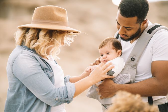 Diverse parents dancing while standing with baby
