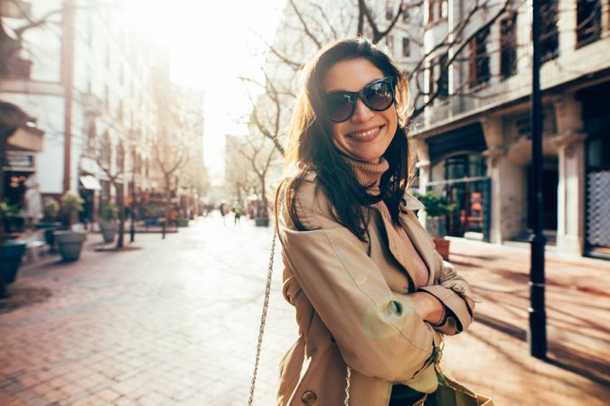Stylish female model with sunglasses on city street