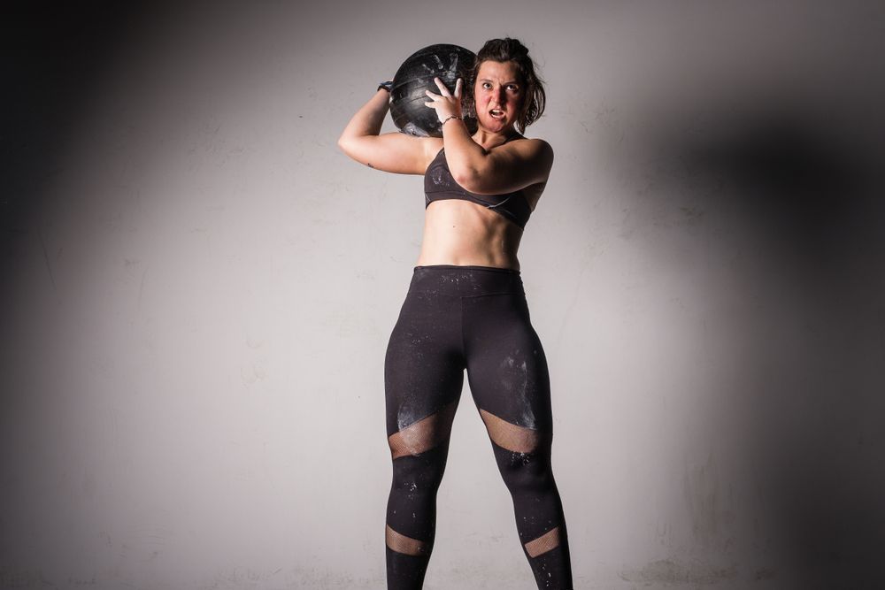 Woman lifting medicine ball in gym