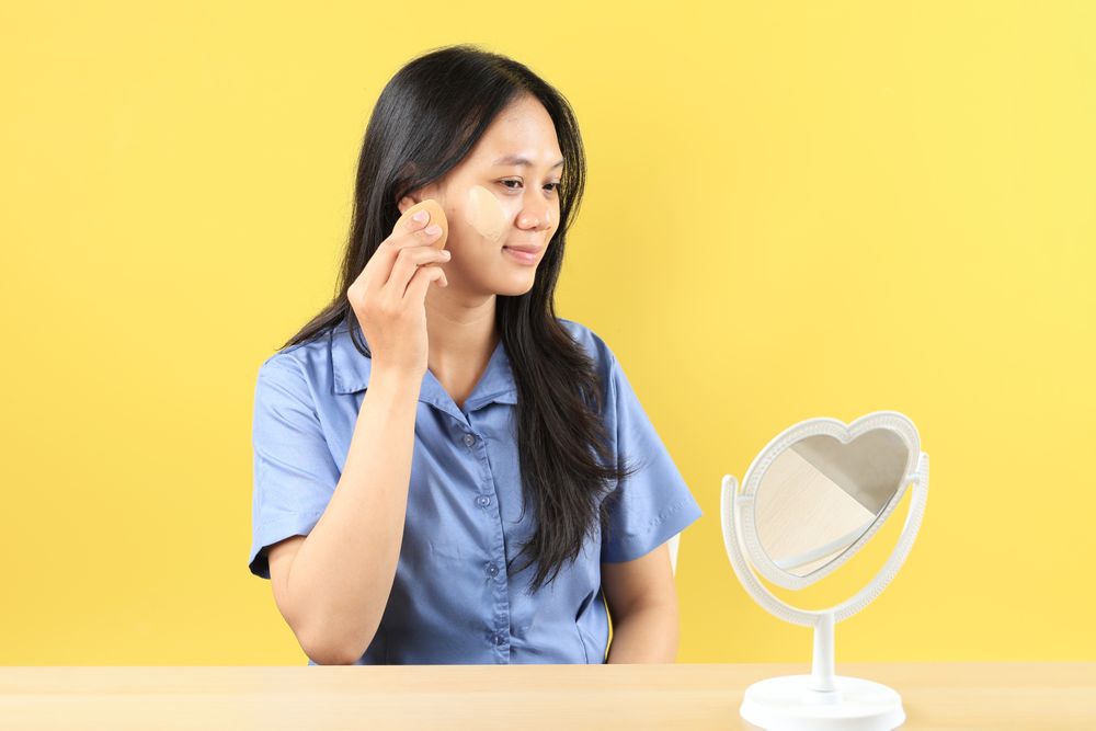 Young Asian Girl Applying Foundation or CC Cream using Beauty Blender