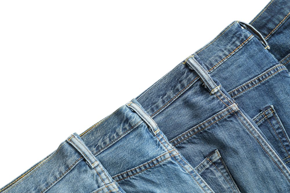Jeans of different colors isolated on light background, space for text