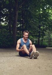 Athletic man stretching in park before a jog