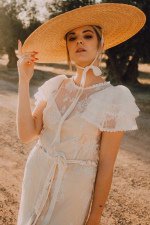 stately woman in hats in bright sunny day