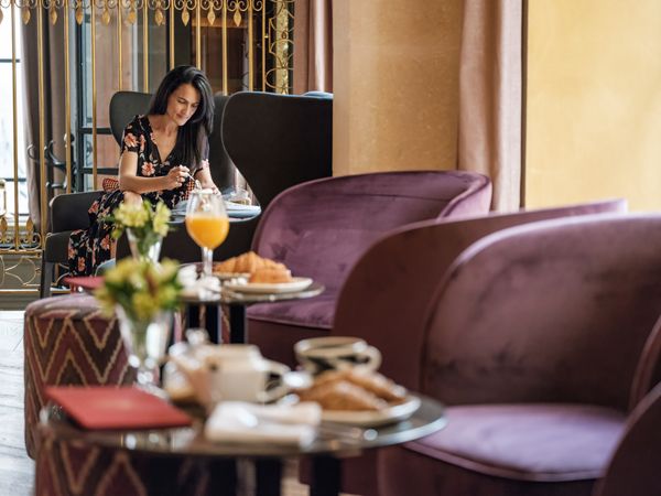 Positive female eating breakfast in luxury restaurant