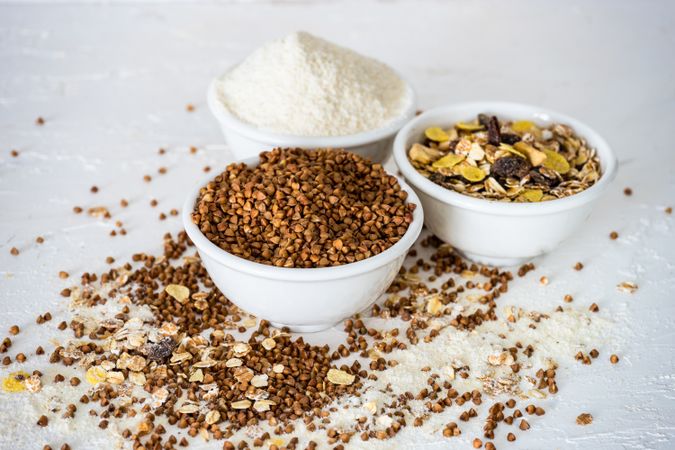 Three separate bowls full of different super food grains on table