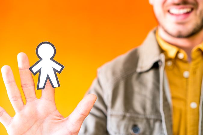 Smiling man holding funny paper toy