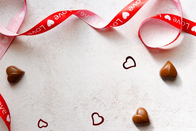 Valentine's Day Concept- Red ribbon with heart chocolates.