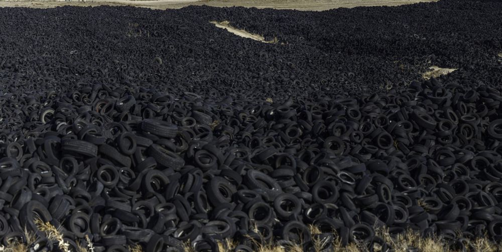 Heap of old tires between field