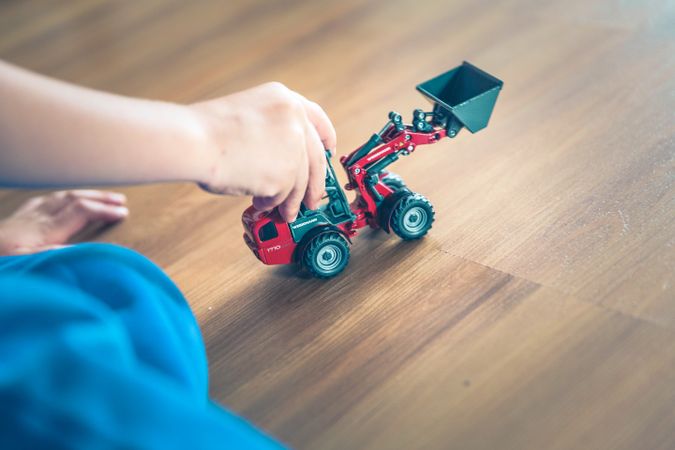 Cropped image of child playing with dump truck toy