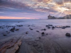 Sundown sky over sea and stony coast