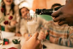 Close-up of sparkling wine being poured into a champagne flute for a toast.