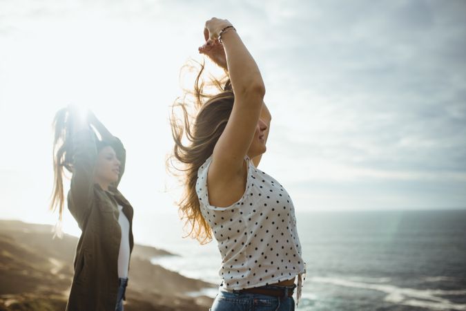 Happy female travelers enjoying freedom at seaside