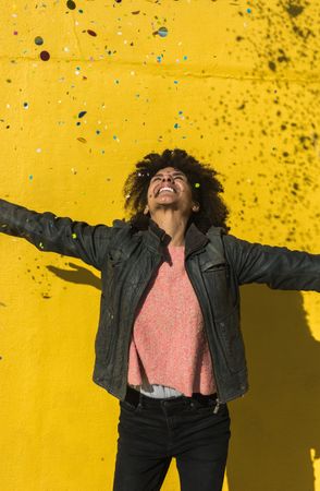 Black woman with afro hair celebrating with confetti.