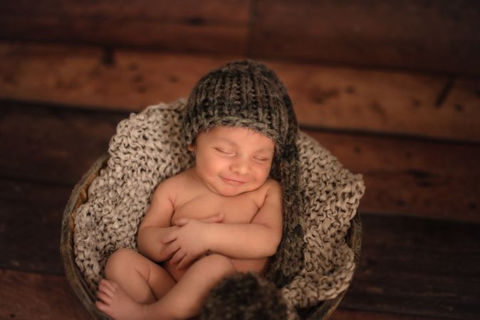 Naked baby sleeping in bucket