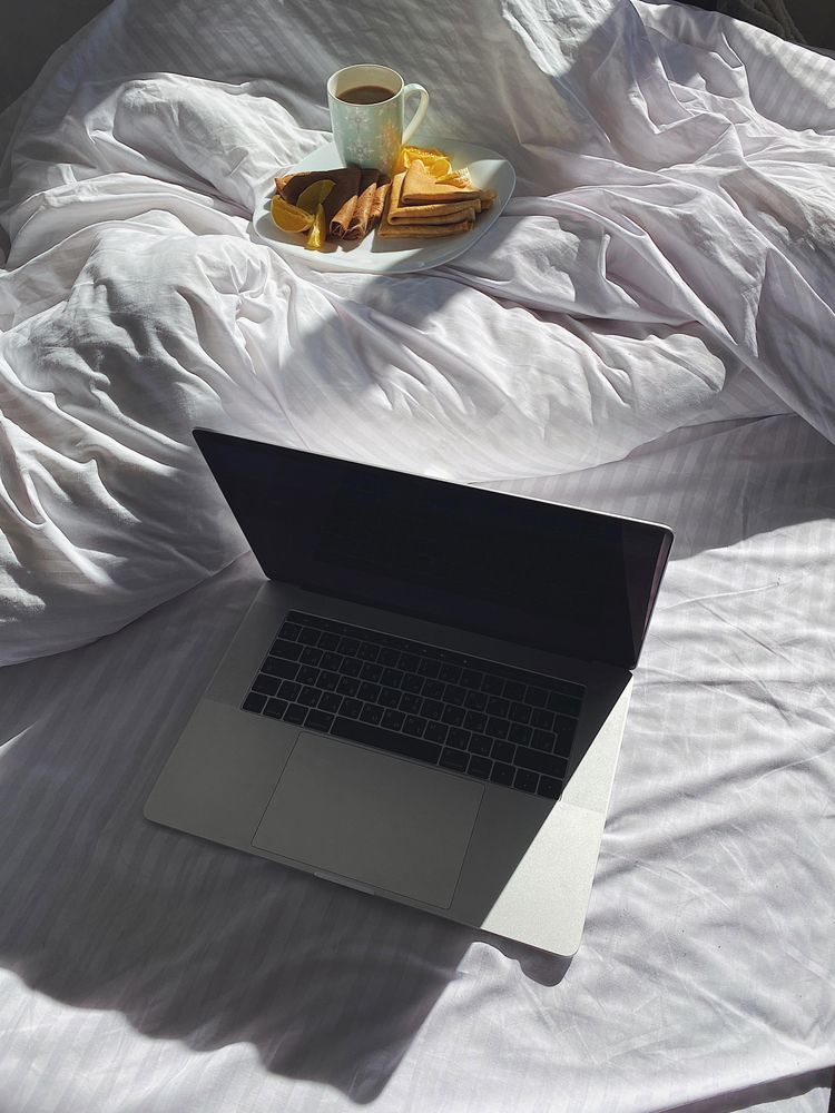 Plate of crepes in bed with laptop
