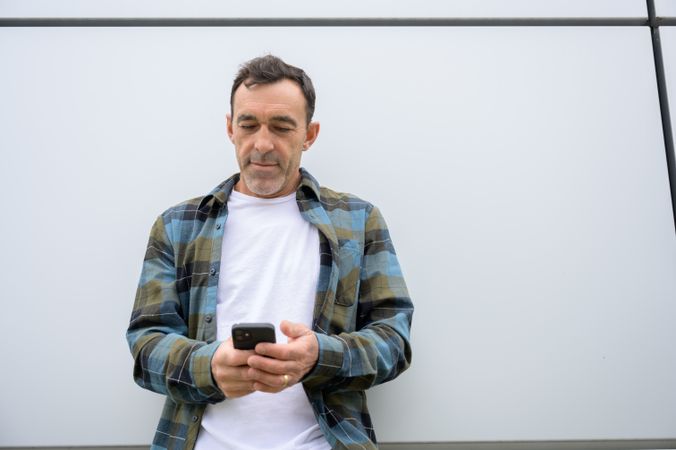 Cheerful man with smartphone looking at screen