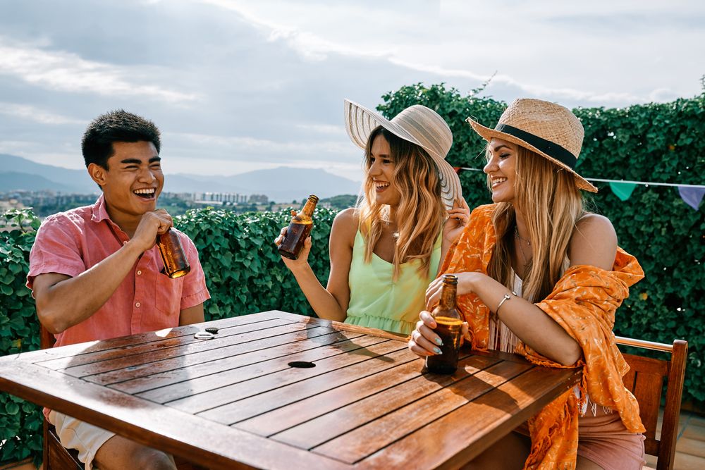 a group of young people having a good time in a summer day and cheering with beer