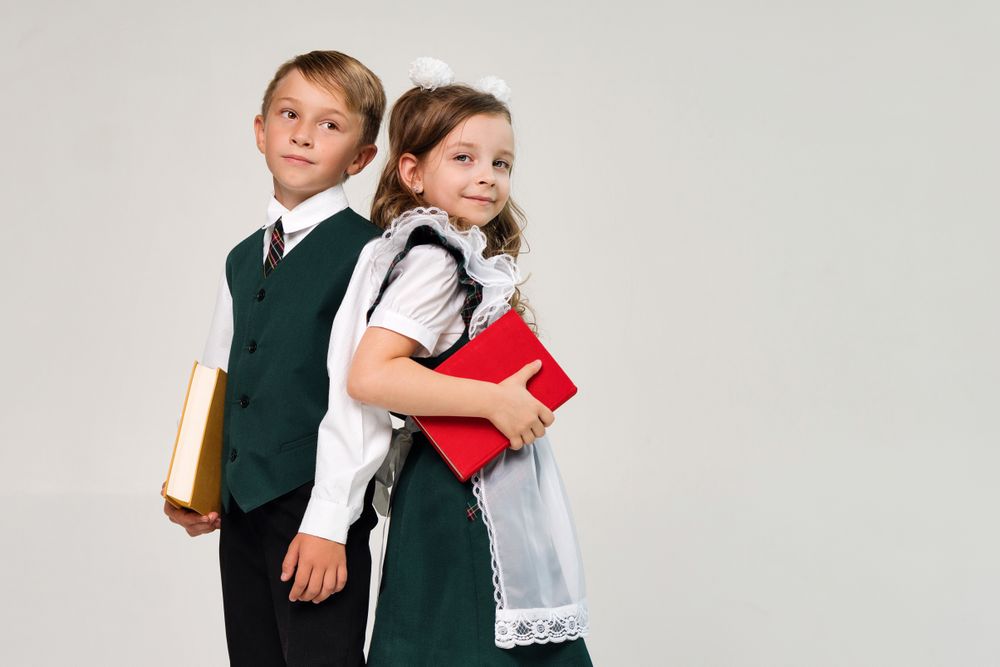Stylish elementary school students stand with their backs to each other