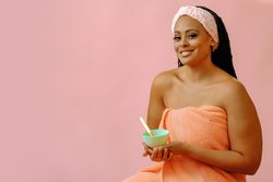 Portrait of a woman in spa towel with bowl of product, copy space