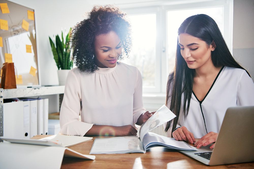 Two female colleagues going over images together for work