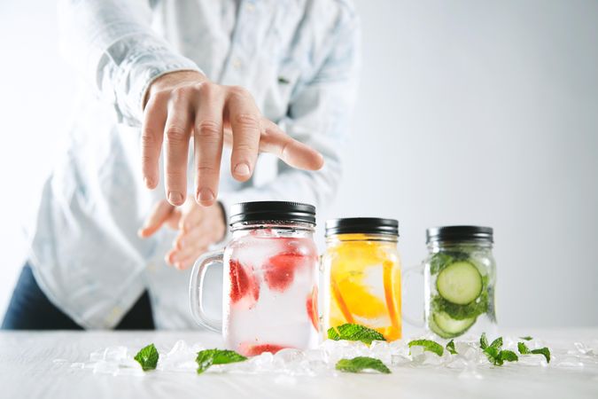 Man reaching for mason jar of infused water
