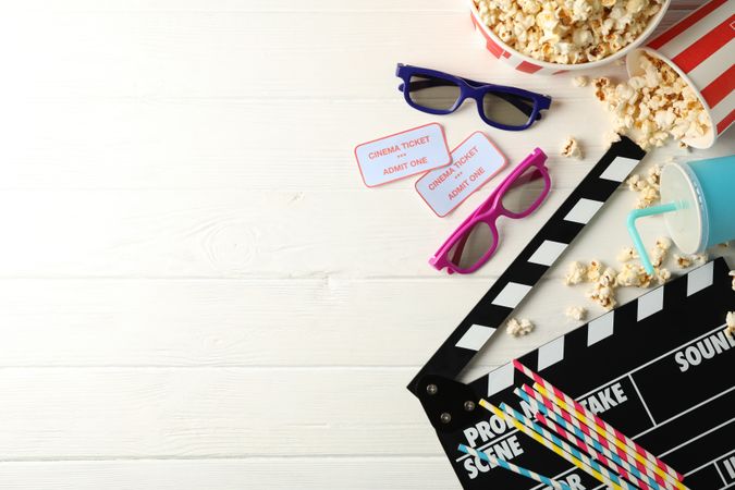 Flat lay. 3d glasses, buckets with popcorn, tickets, clapperboard, drink, on wood background