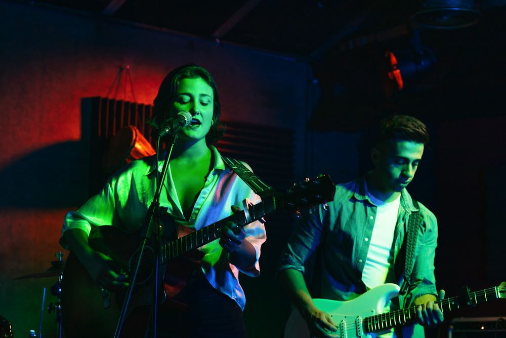 Musicians In Stage With Colorful Lights Performing In A Live Concert