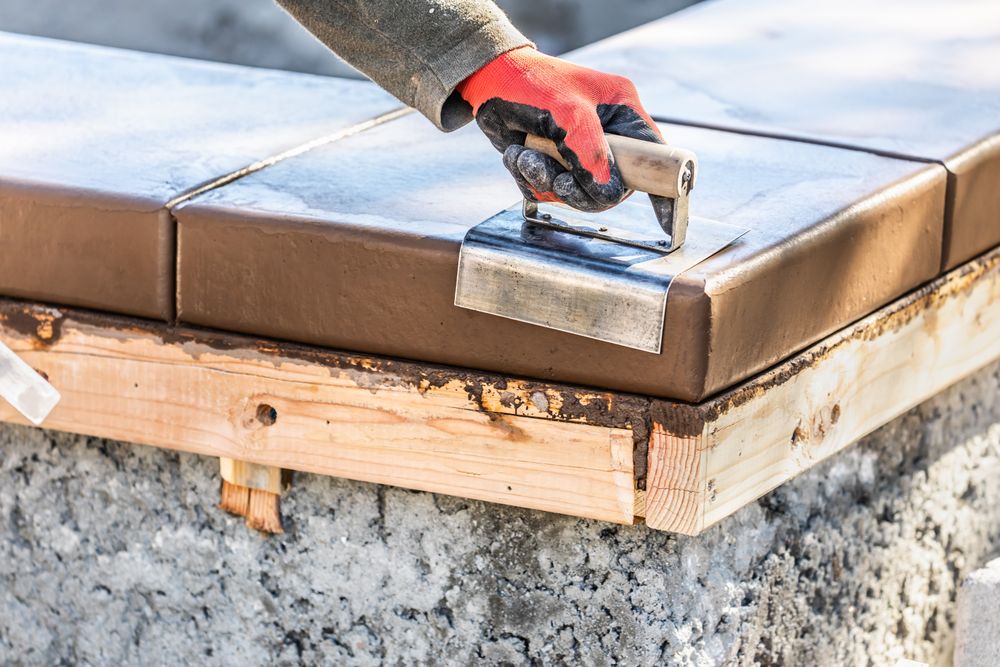Construction Worker Using Stainless Steel Edger On Wet Cement Forming Coping Around New Pool