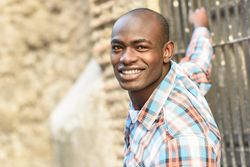 Happy male in plaid shirt leaning off window bars