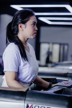 Dedicated woman on a treadmill, focused on fitness routine indoors