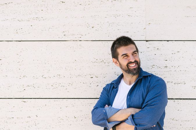 Confident man in denim standing outside with arms crossed