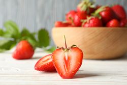 Bowl with tasty strawberry on wooden table. Summer berry