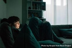 Boy using phone and sitting on couch bDGzE4