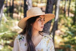 Portrait of a woman with a straw hat in the forest
