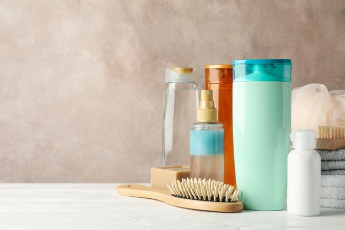 Composition with hair care products on wooden table. Blank space for label
