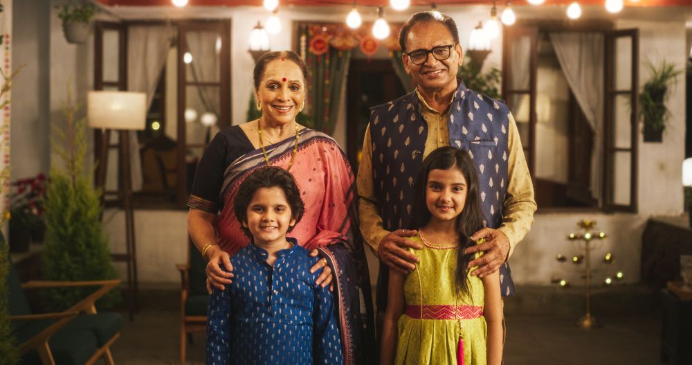 Portrait of Indian Family in Traditional Clothes Posing Together in Authentic Mumbai House.