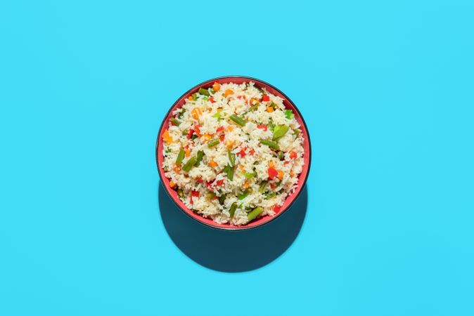 Fried rice bowl above view on a blue background