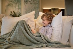 Cheerful boy reading book on couch
