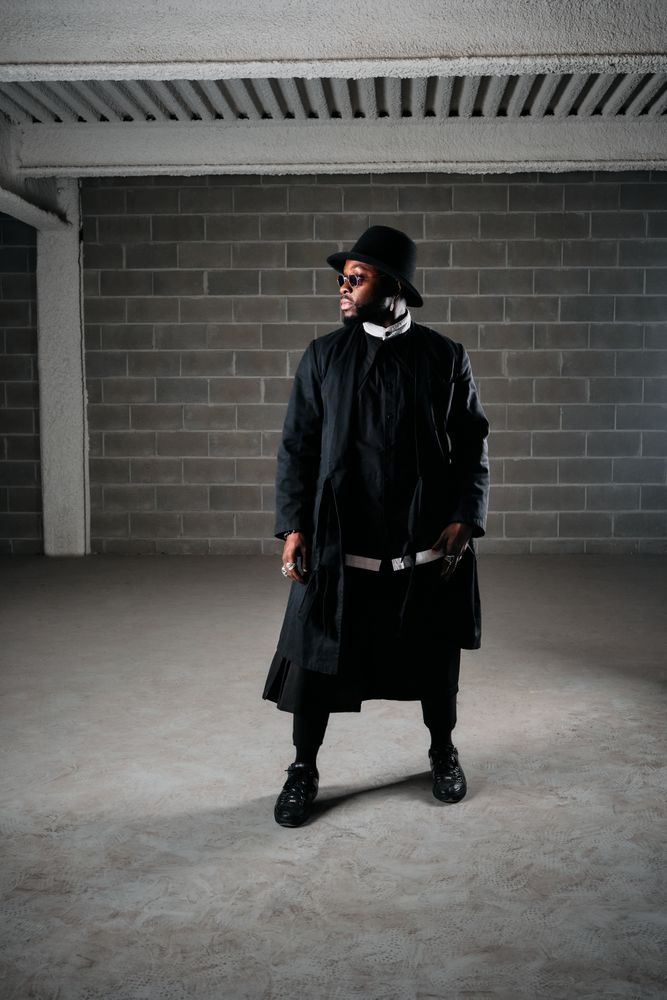 Male in stylish wear standing near dark walls