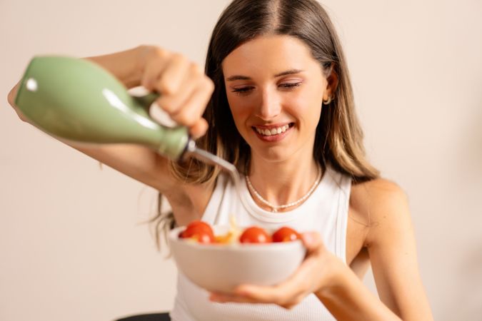 Woman Pouring Olive Oil on Salad - Fresh and Healthy Preparation