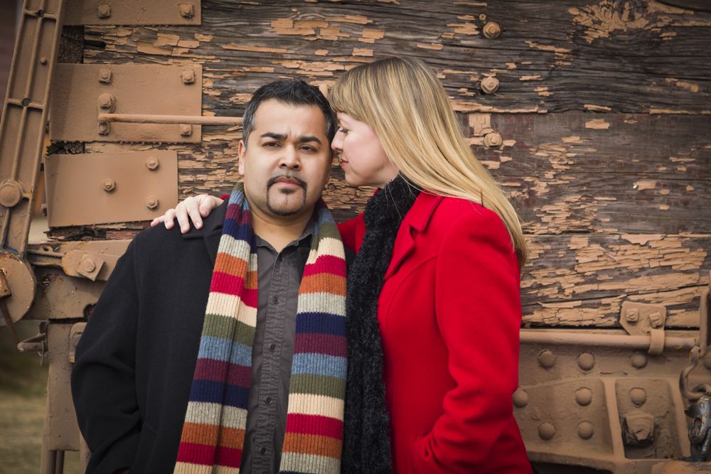 Couple Portrait in Winter Clothing Against Rustic Train