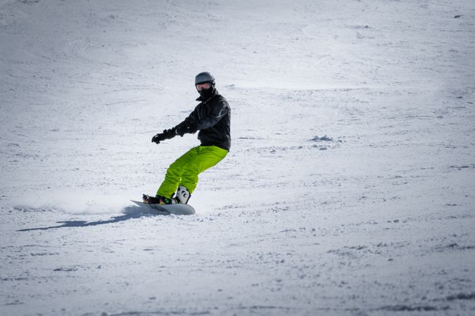 Unrecognizable snowboarder riding on slope