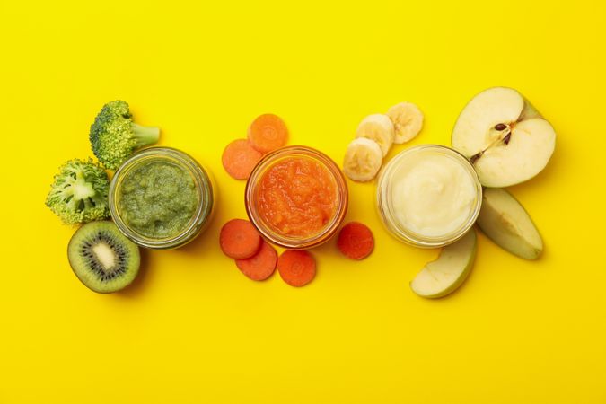 Composition with vegetable puree on yellow background. Baby food